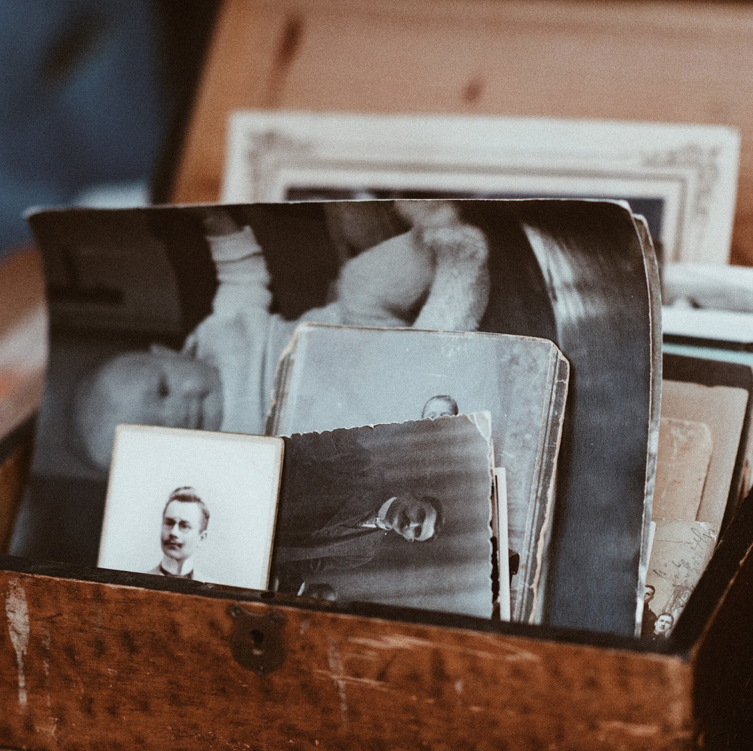 Box of old black and white photos of various sizes